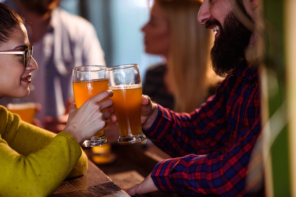 Группа молодых друзей в баре пьют пиво  - Фото, изображение