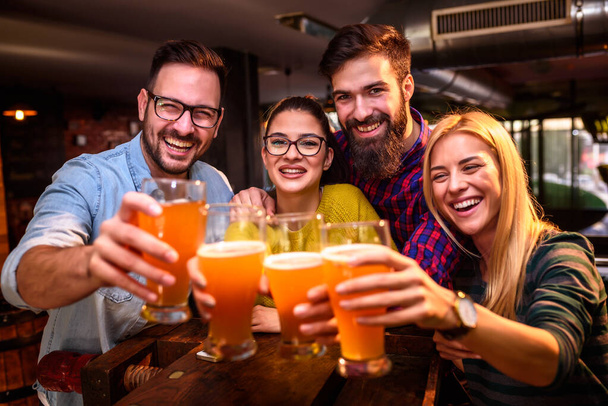 Ryhmä ystäviä juo olutta pubissa
  - Valokuva, kuva