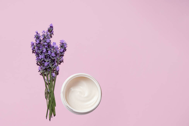 Fresh natural lavender bouquet and a jar of moisturizing cream on a pink background. Flat lay, top view, copy space. - Fotografie, Obrázek