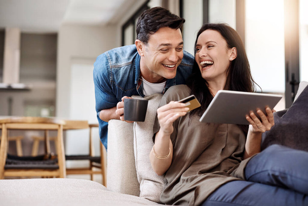 Bu anlaşmayı yaptığımıza inanamıyorum. Evde dijital tablet ve kredi kartı kullanan mutlu genç bir çift. - Fotoğraf, Görsel