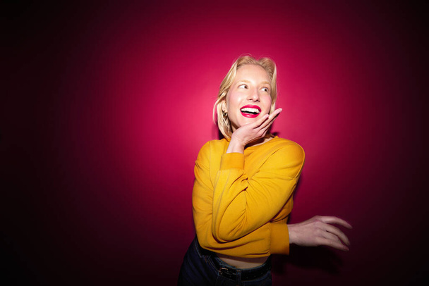 Porträt eines glücklichen Mädchens, das lacht und isoliert auf magenta Hintergrund posiert. Viva magenta, Farbe des Jahres. - Foto, Bild