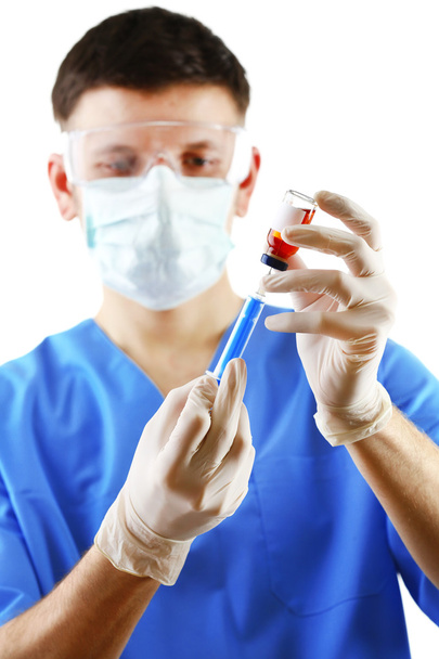 Doctor dialing medicine into syringe from glass bottle isolated on white background - Valokuva, kuva