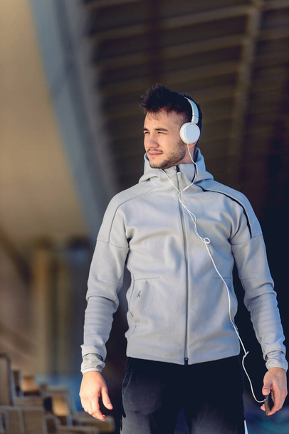 νεαρός άνδρας που ακούει μουσική με ακουστικά - Φωτογραφία, εικόνα
