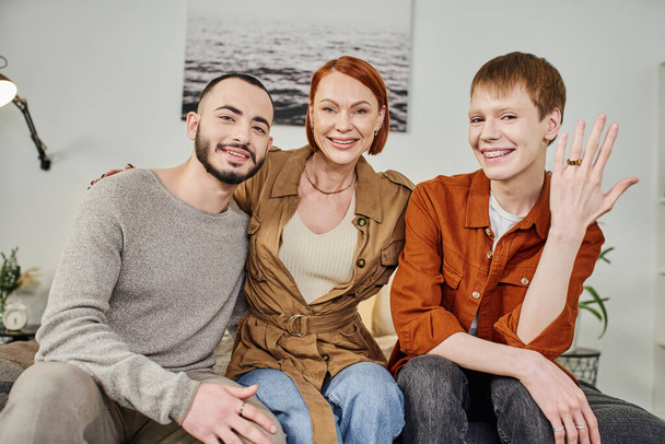 excited gay man showing wedding ring while smiling at camera with mother and boyfriend at home - Valokuva, kuva