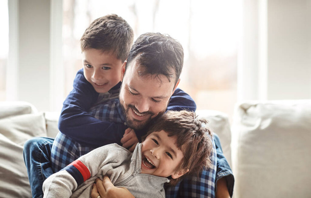 The family that plays together stays together. Portrait of two adorable little boys having fun with their father at home - Foto, afbeelding