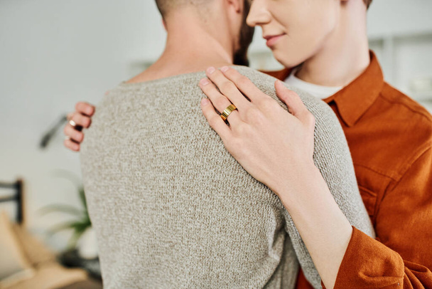 partial view of gay man with wedding ring embracing boyfriend at home - Zdjęcie, obraz