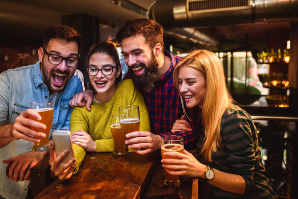 group of friends drinking beer in pub  - Valokuva, kuva