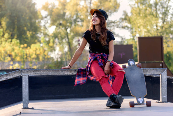 Linda chica urbana con longboard en skate park - Foto, imagen