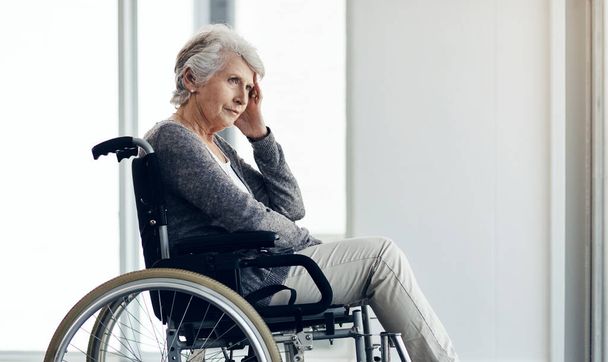 No puedo recordar mucho. una mujer mayor mirando reflexivo mientras está sentado en su silla de ruedas - Foto, imagen