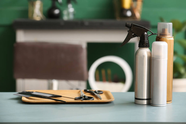 Hair sprays and different accessories on table in beauty salon - Fotoğraf, Görsel