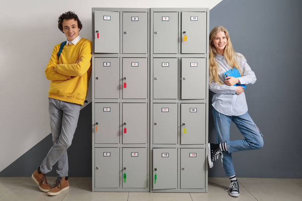 Симпатичная пара подростков возле шкафчика в школе - Фото, изображение