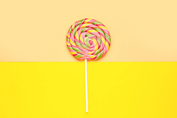 Colorful lollipop on yellow and beige background - Fotoğraf, Görsel