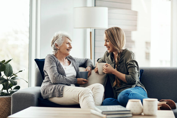 Adoro le nostre chiacchierate. una donna anziana e sua figlia adulta seduti insieme a casa - Foto, immagini