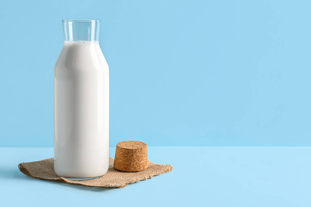 Botella con leche fresca sobre fondo azul - Foto, imagen