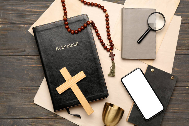 祈りのビーズと聖書,クロス,携帯電話,ノートブックや暗い木製の背景に紙シート - 写真・画像