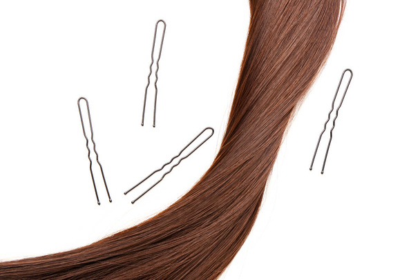 Brown hair with pins on white background - Fotó, kép