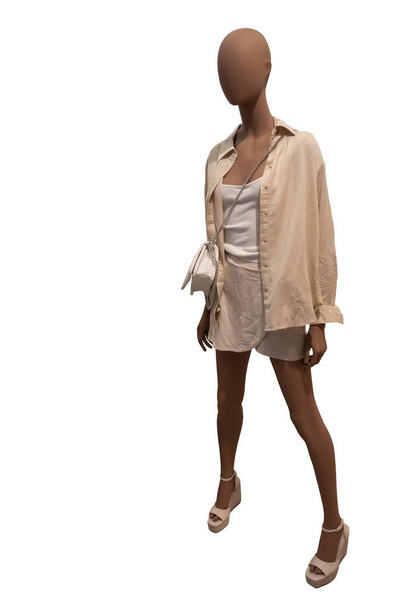 Image pleine longueur d'un mannequin d'étalage féminin portant une chemise déboutonnée et une jupe courte sur fond blanc - Photo, image