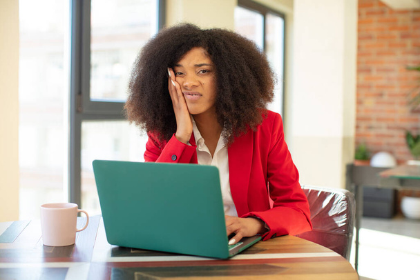 pretty afro black woman feeling bored, frustrated and sleepy after a tiresome. businesswoman and laptop concept - Foto, imagen