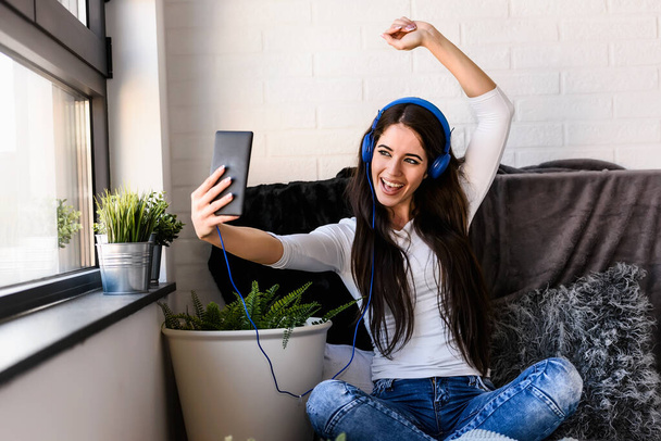 young woman with headphones listening music and making selfie - Foto, Imagem