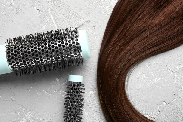 Brown hair with round brushes on grunge background, closeup - Photo, Image