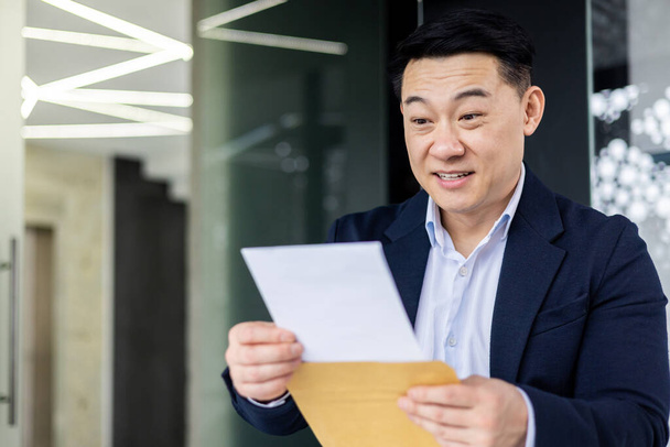 Successful asian businessman working inside office with laptop at workplace male boss in business suit received notification mail envelope with good news, entrepreneur happy with achievement results. - Fotografie, Obrázek