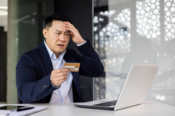 Cheated and disappointed businessman working inside office, man trying to transfer money and online purchase, fraudulent activity received credit card access error. - Fotoğraf, Görsel