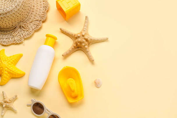 Sunscreen cream for baby with beach accessories and starfishes on beige background - Photo, Image