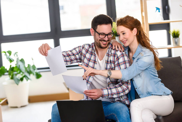 glückliches junges Paar nutzt Laptop und zieht in ein neues Zuhause - Foto, Bild