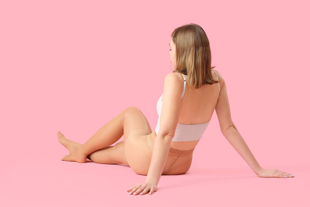Beautiful young woman in beige tights on pink background - Foto, afbeelding