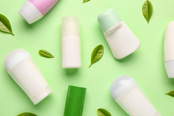 Deodorants with leaves on light green background - Photo, Image