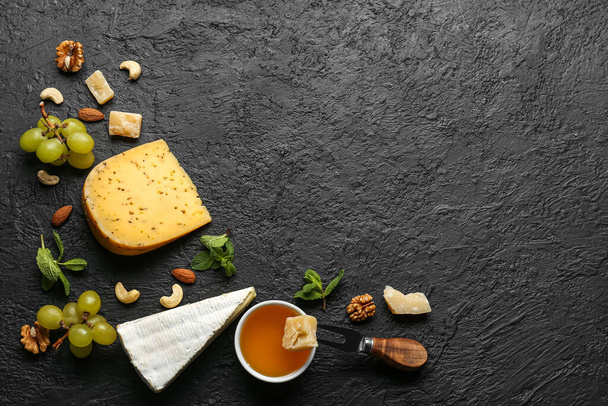 Cornice in gustoso formaggio, noci, uva e miele su sfondo scuro - Foto, immagini