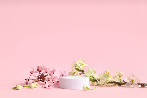 Decorative podium and blooming branches on pink background - Foto, Imagem