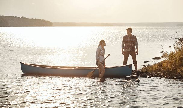 Escapar al lago en un kayak. una joven pareja que va a dar un paseo en canoa por el lago - Foto, Imagen