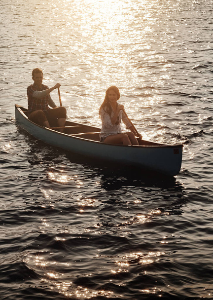 Dem Lauf des Abenteuers folgen. ein junges Paar rudert mit einem Boot auf dem See - Foto, Bild
