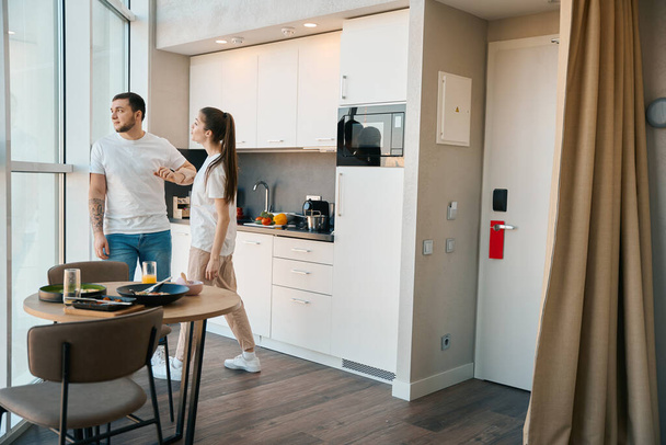 Emotional spouses quarrel in the kitchen, caring man walks away from conflict - Photo, Image