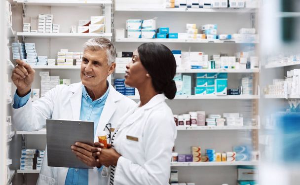 Travailler ensemble pour fournir le meilleur service. deux pharmaciens travaillant ensemble dans une pharmacie - Photo, image