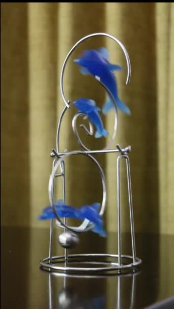 blauwe dolfijn vormige slinger swingend op een tafel - Video