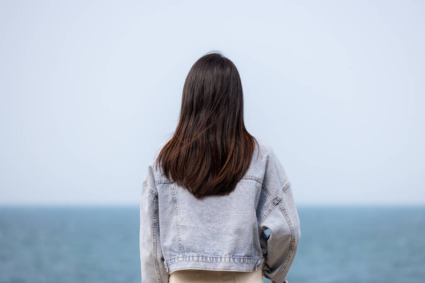 Жінка насолоджується видом на океан моря
 - Фото, зображення