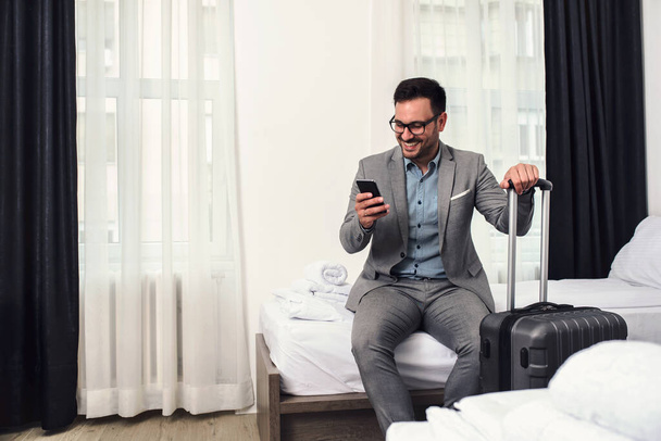 young man with a suitcase in the hotel room - Fotoğraf, Görsel