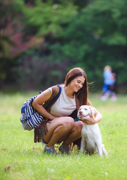 belle fille s'amuser avec son chiot labrador dans le parc - Photo, image