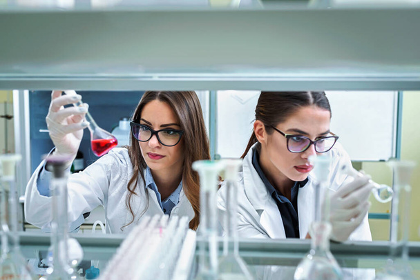 молодые женщины-ученые, работающие в лаборатории  - Фото, изображение
