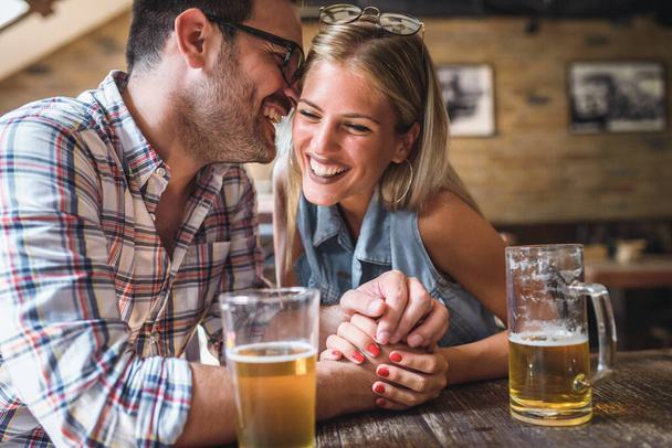 couple drinking beer in pub - Фото, изображение