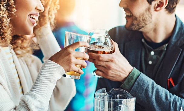 Esta data só nos aproximou mais. um jovem casal mexendo seus copos de cerveja juntos em um pub - Foto, Imagem