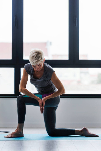 Mujer mayor haciendo ejercicios de yoga
 - Foto, imagen
