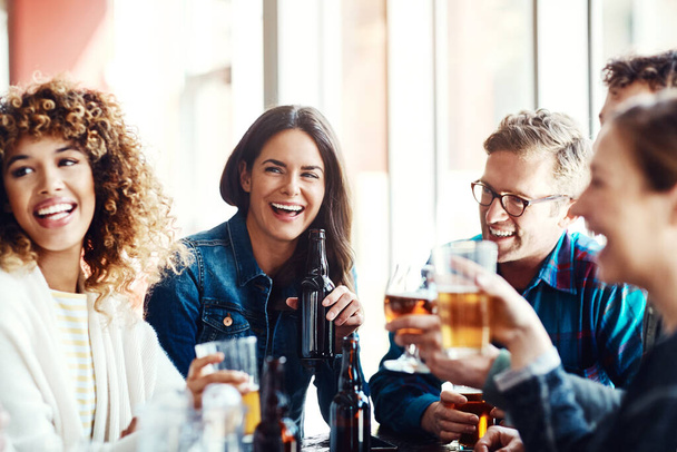 Rentoutua ystävien kanssa töiden jälkeen. ryhmä ystäviä nauttimassa olutta baarissa - Valokuva, kuva