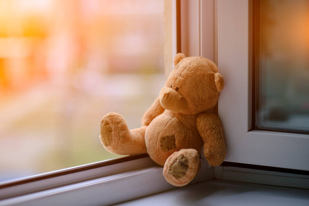 Bear childrens soft toy sitting edge an open window.Concept accidents with children - Foto, afbeelding