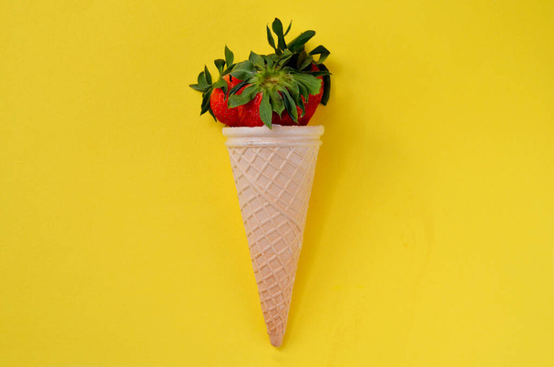strawberries in a waffle cone on a yellow background - Zdjęcie, obraz