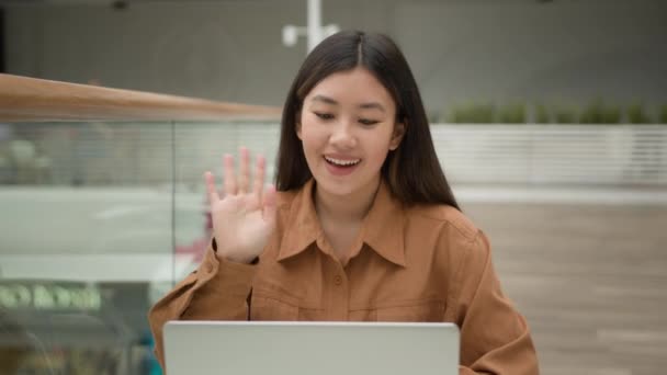 Ázsiai nő lány alkalmazott vállalkozó beszélni laptop számítógépen online video hívás távolság hívás virtuális webkamera chat mosolygó kínai koreai japán etnikai üzletasszony munkavállaló beszél ül a kávézóban - Felvétel, videó