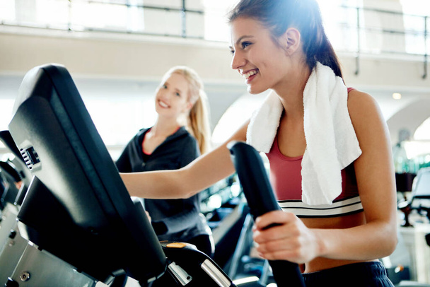 Faster. attractive young women working out on treadmills at the gym - Photo, Image