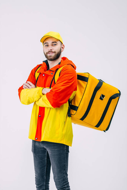Young courier with a thermal bag on a white background, place. Food delivery service. - Photo, image